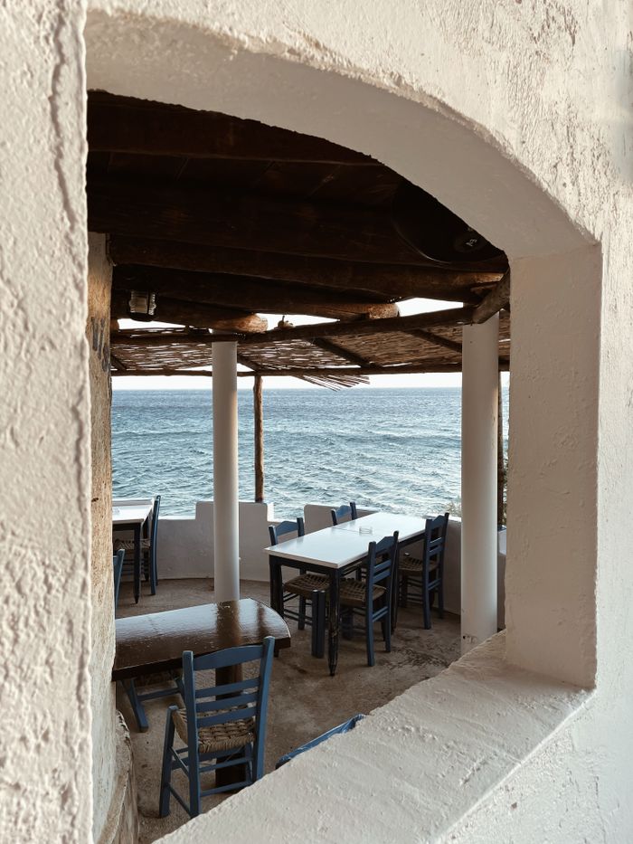 Peaceful al fresco dining setup overlooking the ocean in Pefkos, Greece.
