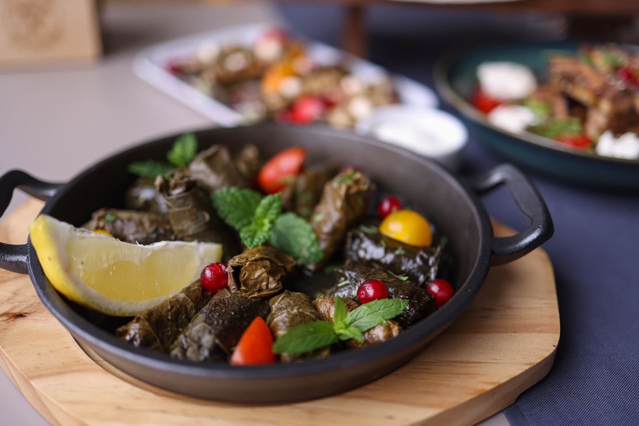 Delicious traditional dolma served with fresh garnish and lemon in a rustic setting.